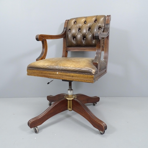 2210 - An early 20th century mahogany and button-back studded leather upholstered swivel desk chair, with r... 