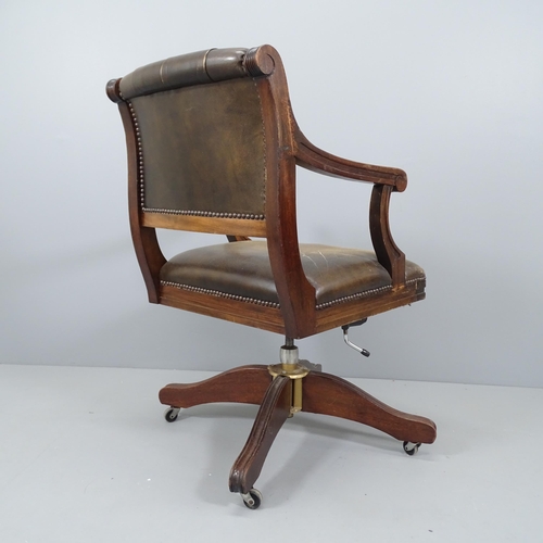 2210 - An early 20th century mahogany and button-back studded leather upholstered swivel desk chair, with r... 