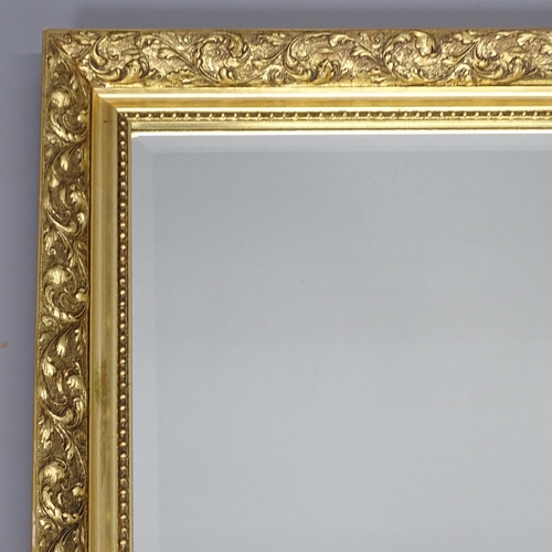 2233 - A modern gilt-framed wall mirror. 132x103cm