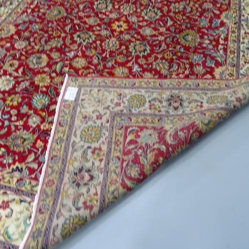 2281 - A red and cream-ground Tabriz carpet, with floral design. 338x298cm