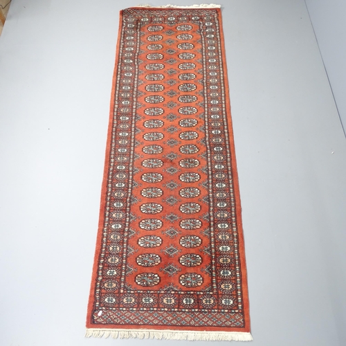 2258 - An orange-ground Afghan runner. 245x83cm