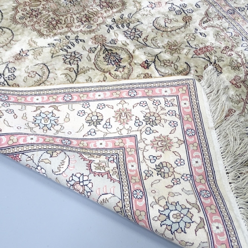 2261 - A cream-ground Persian silk rug. 150x94cm