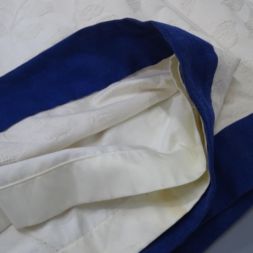 2288 - A pair of cream-ground lined curtains with contrasting blue border. Drop 81