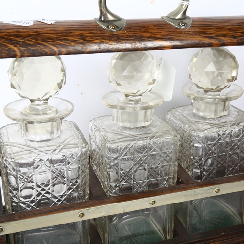 749 - A silver plated oak tantalus, with 3 cut-glass decanters and stoppers, L33.5cm