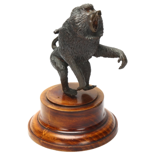 4 - A cast bronze sculpture of a baboon on turned wooden plinth, height 17cm