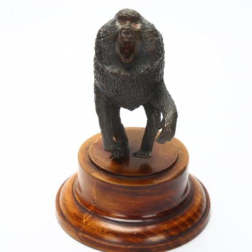 4 - A cast bronze sculpture of a baboon on turned wooden plinth, height 17cm