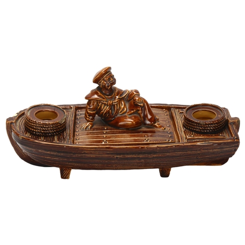 9 - A 19th century novelty majolica inkwell in the form of a sailor and boat, marked R.H. 18 to base, le... 