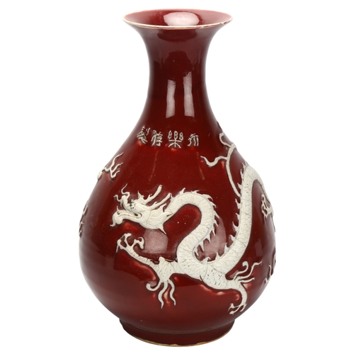 109 - A large Chinese porcelain Sang de Boeuf 'Dragon' pear-shaped vase, Yuhuchunping, with applied dragon... 