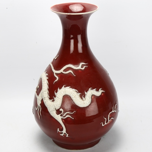 109 - A large Chinese porcelain Sang de Boeuf 'Dragon' pear-shaped vase, Yuhuchunping, with applied dragon... 