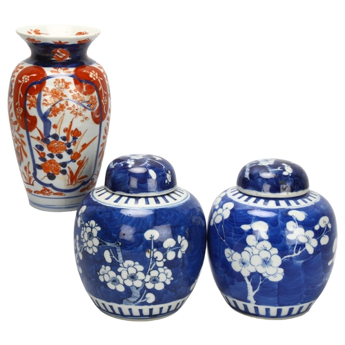 121 - A pair of blue and white prunus jars, with 4 character marks to base, and an Imari vase, tallest 18.... 