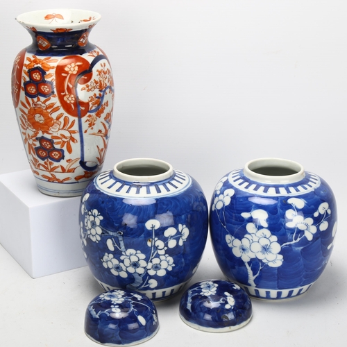 121 - A pair of blue and white prunus jars, with 4 character marks to base, and an Imari vase, tallest 18.... 