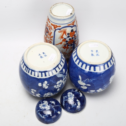 121 - A pair of blue and white prunus jars, with 4 character marks to base, and an Imari vase, tallest 18.... 