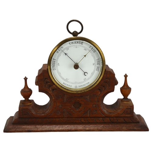 38 - A brass-cased aneroid barometer, maker's mark SJL & Co, on fitted Gothic oak base, width 22cm