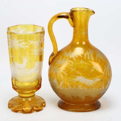 66 - A Bohemian amber flashed glass stag drinking set, comprising moon flask ewer and goblet, goblet heig... 