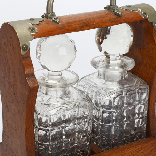 78 - An oak 2-bottle tantalus, with square section decanters, no key, W23cm, D13cm, H31cm