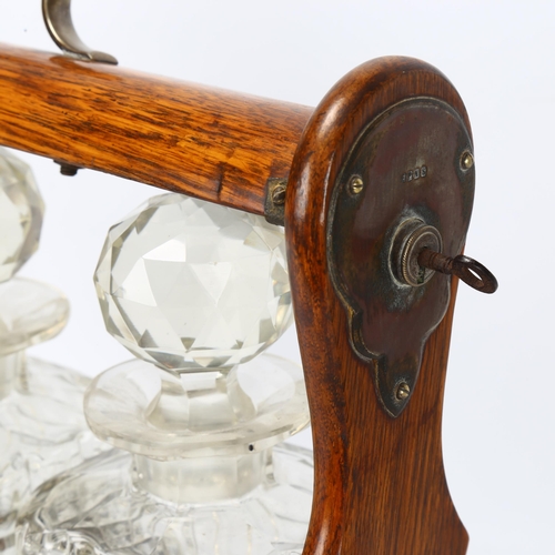 131 - A late 19th/early 20th century 3-bottle oak tantalus, length 35.5cm