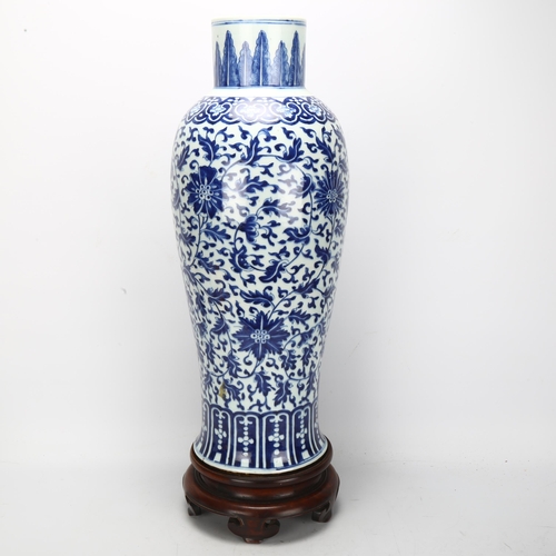 198 - A large Chinese blue and white baluster vase with floral decoration, on wooden stand, height of vase... 