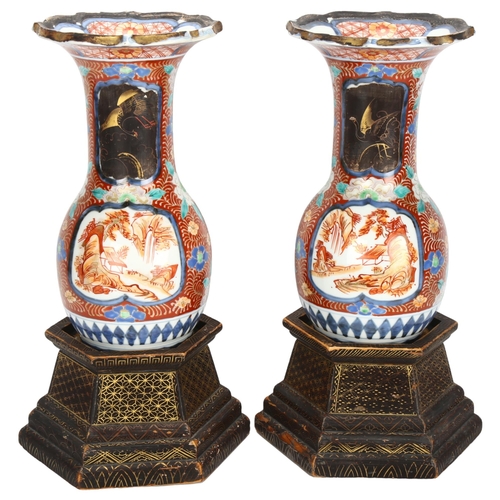 263 - A pair of Japanese Imari vases on painted lacquer wooden stands, with overpainted lacquer panels and... 