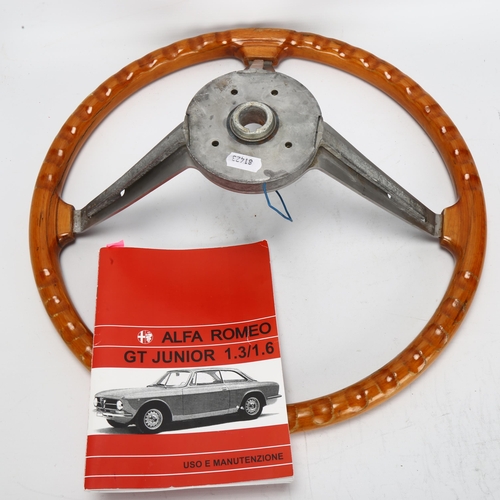 525 - An Alfa Romeo steering wheel and user manual for GT Junior, engraved on metal 