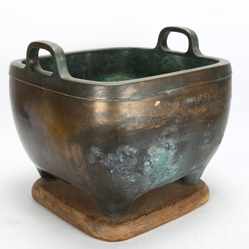 265 - A large Chinese bronze planter, with engraved decoration and silver inlay Greek key border, on woode... 