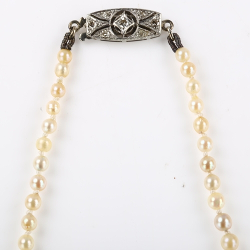 1151 - A graduated single-strand pearl necklace, with unmarked white metal diamond set clasp, pearls rangin... 