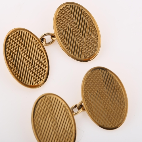 1153 - A pair of Art Deco 9ct gold cufflinks, oval panels with engine turned decoration, maker's marks EAP,... 