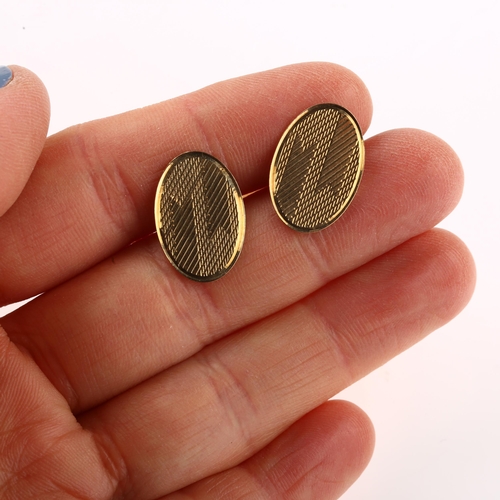 1153 - A pair of Art Deco 9ct gold cufflinks, oval panels with engine turned decoration, maker's marks EAP,... 