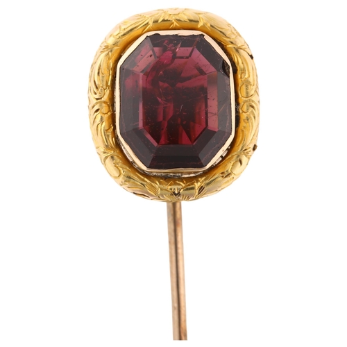 1154 - A Georgian almandine garnet tie pin, unmarked gold settings with foliate engraved border, head heigh... 