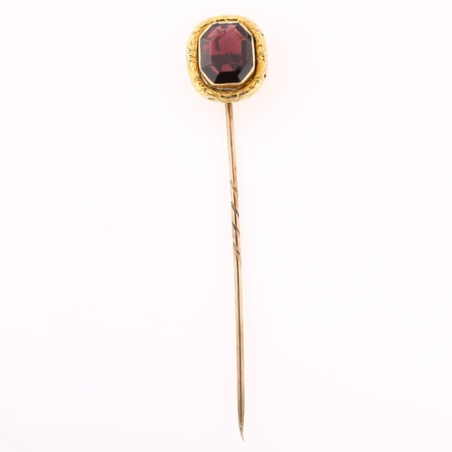 1154 - A Georgian almandine garnet tie pin, unmarked gold settings with foliate engraved border, head heigh... 