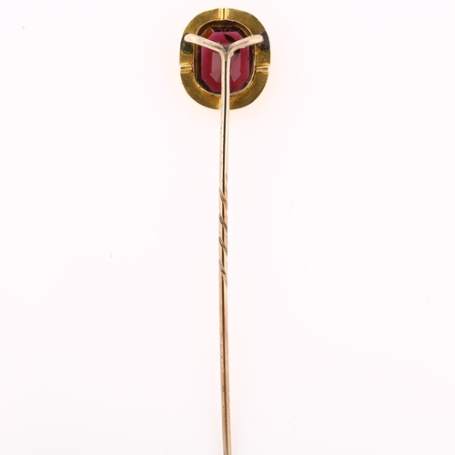 1154 - A Georgian almandine garnet tie pin, unmarked gold settings with foliate engraved border, head heigh... 