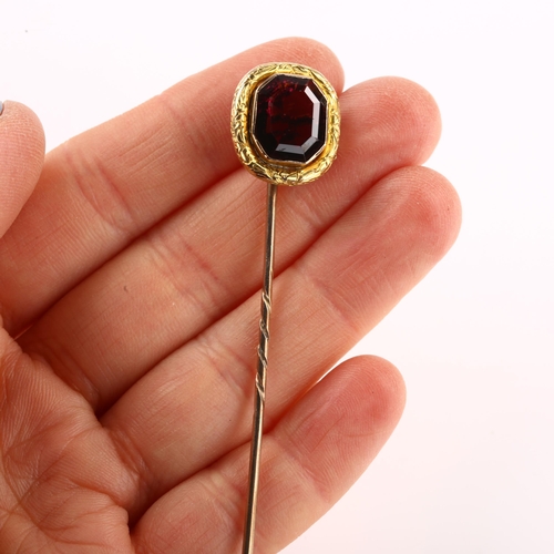 1154 - A Georgian almandine garnet tie pin, unmarked gold settings with foliate engraved border, head heigh... 