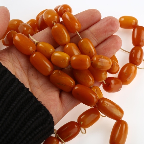 1155 - A single-strand butterscotch amber barrel bead necklace, bead lengths ranging from 227.4 - 15.6mm, n... 