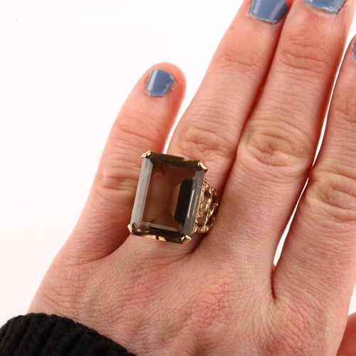 1167 - A large 1970s smoky quartz dress ring, unmarked 9ct gold settings with pierced and textured bark des... 