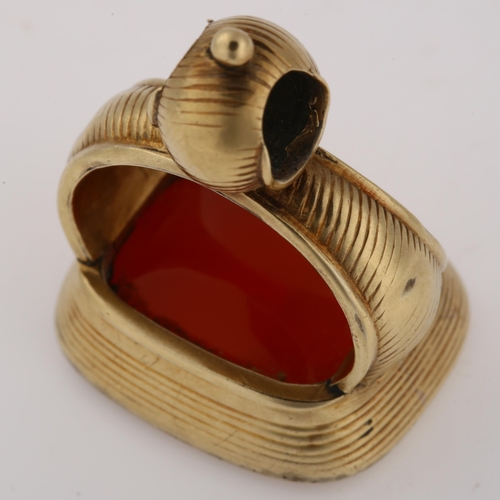 1168 - A 19th century carnelian fob, unmarked yellow metal ribbed frame with blank inset carnelian, carneli... 