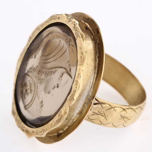 1179 - A 19th century smoky quartz Minerva intaglio seal ring, unmarked gold foliate engraved settings, wit... 