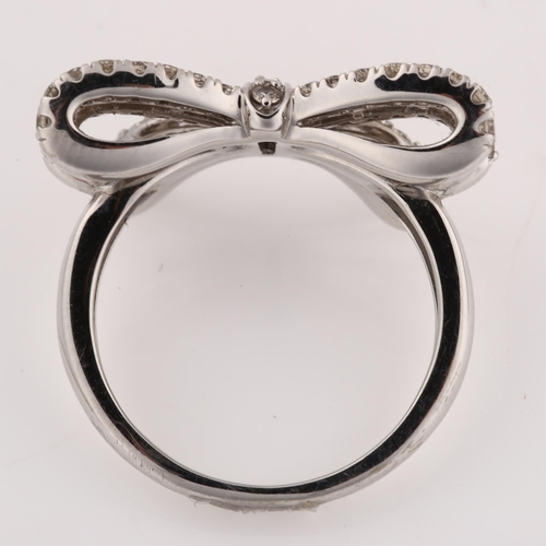 1194 - A modern 9ct white gold diamond ribbon bow ring, set with modern round brilliant and baguette-cut di... 