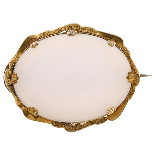 1212 - A Victorian chalcedony memorial brooch, unmarked gold foliate engraved frame with oval cabochon chal... 