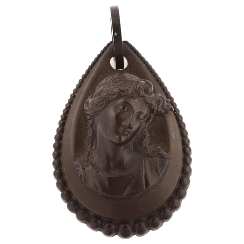 1228 - A large Victorian vulcanite cameo mourning pendant, circa 1880, relief panel depicting Classical fem... 