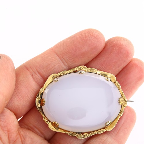 1212 - A Victorian chalcedony memorial brooch, unmarked gold foliate engraved frame with oval cabochon chal... 