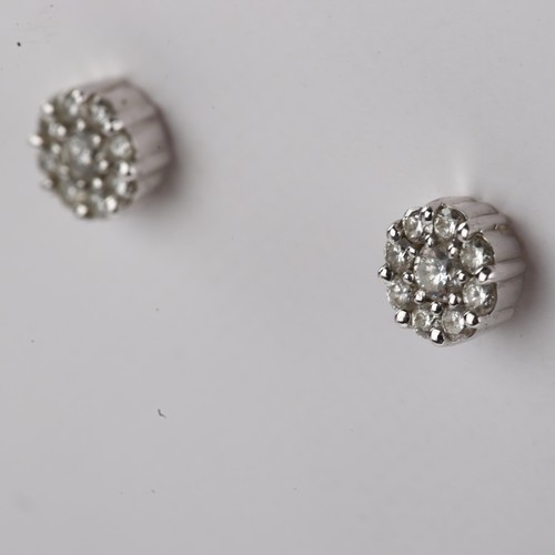 1221 - A pair of 18ct white gold diamond cluster earrings, set with modern round brilliant-cut diamonds and... 