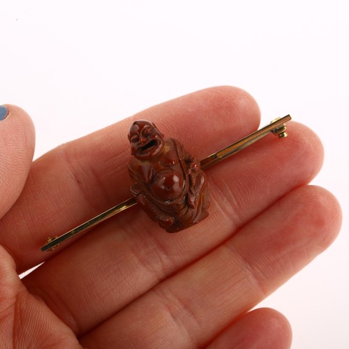 1226 - A Chinese carved olive nut Budai bar brooch, unmarked gold curved settings, brooch length 56.6mm, 5g