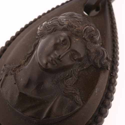 1228 - A large Victorian vulcanite cameo mourning pendant, circa 1880, relief panel depicting Classical fem... 