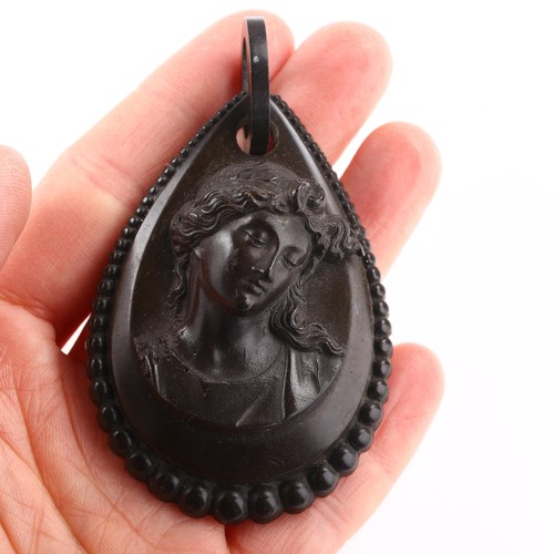 1228 - A large Victorian vulcanite cameo mourning pendant, circa 1880, relief panel depicting Classical fem... 