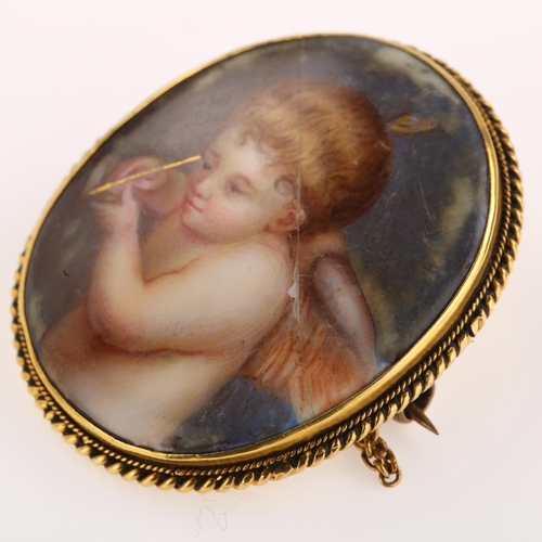 1247 - A 19th century miniature porcelain brooch, hand painted panel depicting cherub, in unmarked yellow m... 