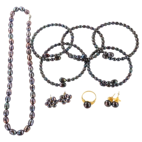 1253 - A black freshwater pearl jewellery set, comprising unmarked yellow metal ring (3.9g), 2 pairs of stu... 