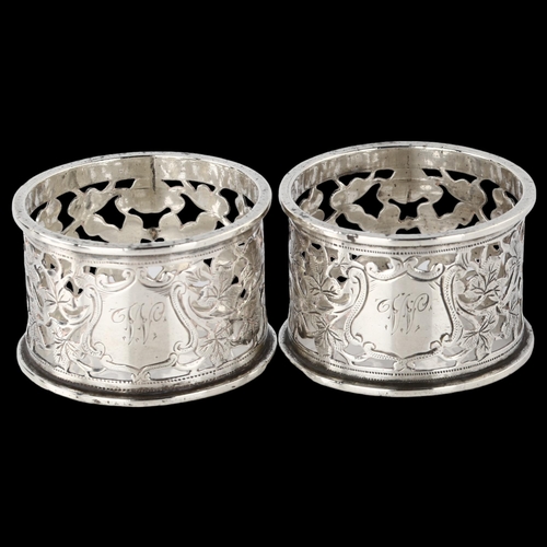 1541 - A pair of Edwardian silver napkin rings, with pierced and engraved leaf decoration, by George Nathan... 