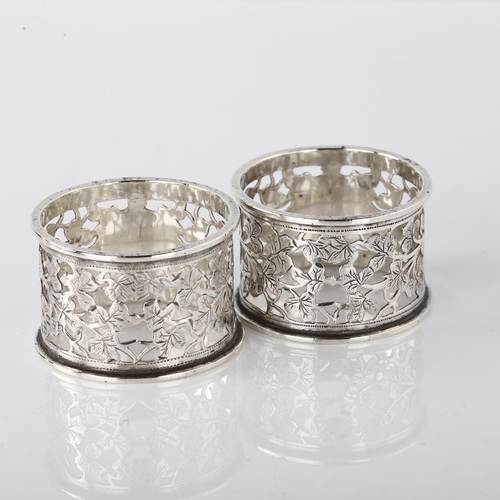 1541 - A pair of Edwardian silver napkin rings, with pierced and engraved leaf decoration, by George Nathan... 