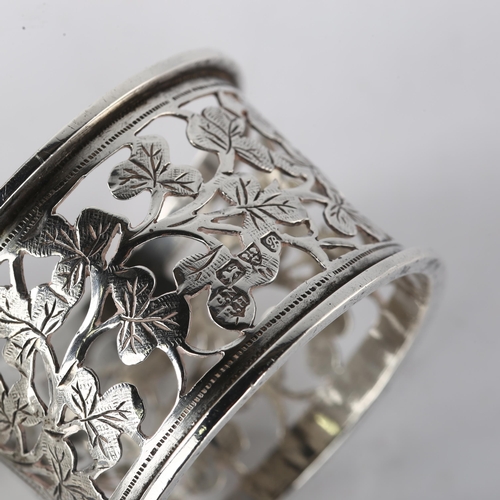 1541 - A pair of Edwardian silver napkin rings, with pierced and engraved leaf decoration, by George Nathan... 