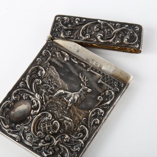 1570 - A George V silver 'Monarch of the Glen' castle-top card case, with allover relief embossed foliate d... 