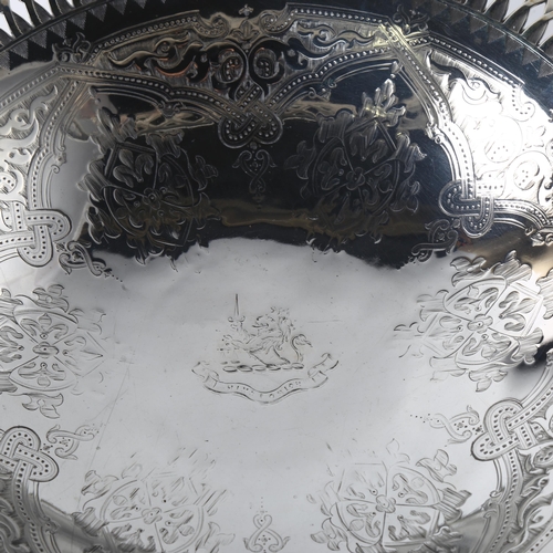 1602 - A large Victorian silver swing-handled bread basket, with engraved decoration, rampant lion crest an... 